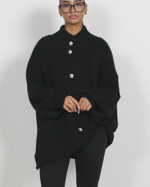 Mörk stickad kofta med markerad struktur – avslappnad styrka i svart