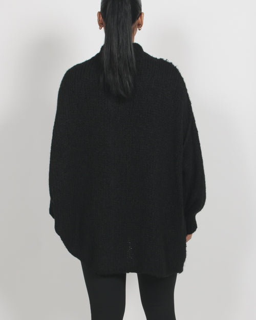 Mörk stickad kofta med markerad struktur – avslappnad styrka i svart